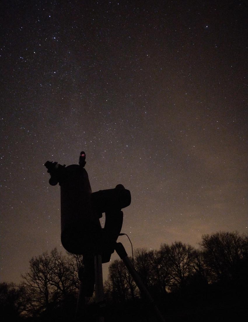 Photo à prise longue d'un téléscope devant une nuit étoilée